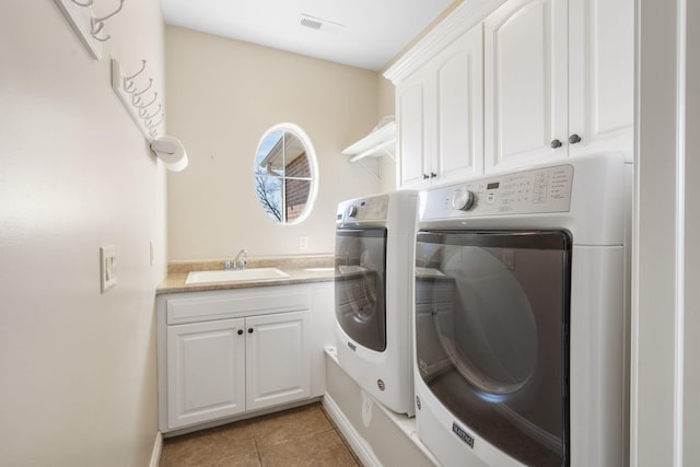 washroom featuring light tile patterned floors, cabinet space, visible vents, a sink, and independent washer and dryer