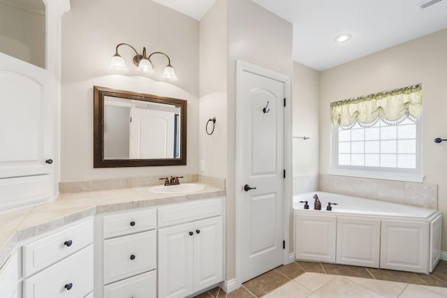 bathroom featuring tile patterned flooring, visible vents, vanity, and a bath