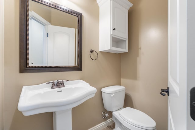 bathroom featuring toilet and baseboards