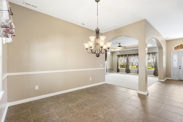 interior space featuring arched walkways, visible vents, baseboards, tile patterned floors, and carpet