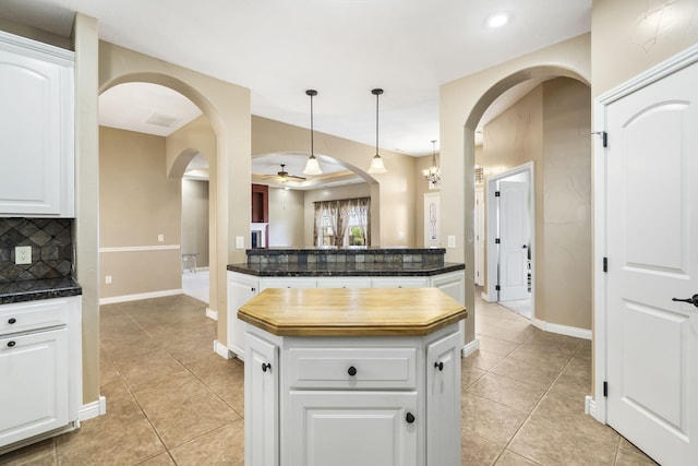 kitchen featuring dark countertops, light tile patterned flooring, and decorative backsplash