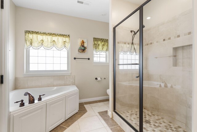 full bathroom featuring a stall shower, tile patterned floors, visible vents, and a bath