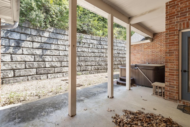 view of patio / terrace featuring a hot tub and fence