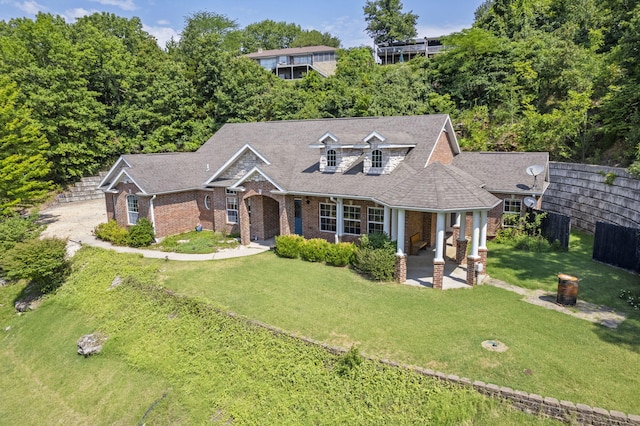 view of front facade featuring brick siding, a front yard, and fence