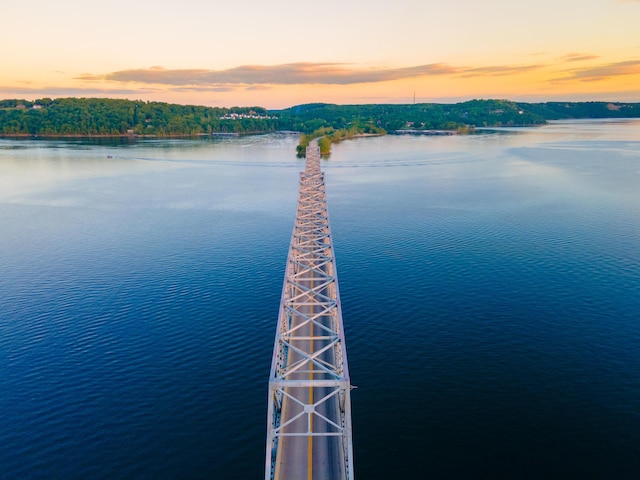 aerial view at dusk featuring a water view