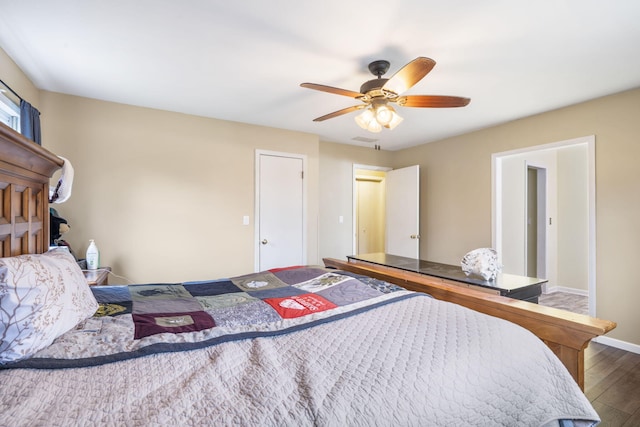 bedroom featuring wood finished floors, visible vents, a ceiling fan, and baseboards