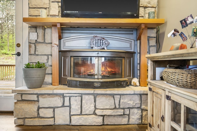 room details featuring a glass covered fireplace and wood finished floors
