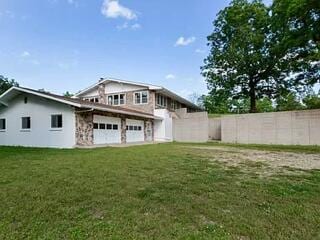 rear view of property with a yard and a garage