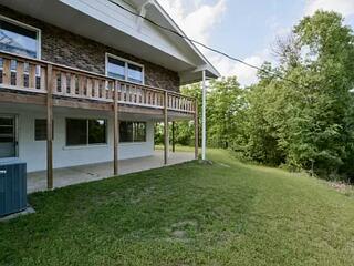 rear view of house featuring central AC, a patio area, and a lawn