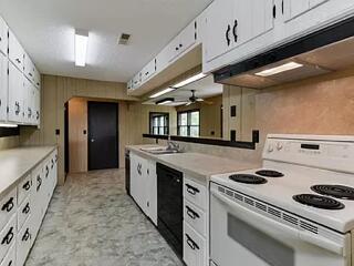 kitchen featuring dishwasher, ceiling fan, white electric range oven, and white cabinetry