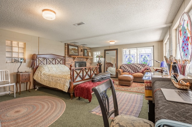 carpeted bedroom with a brick fireplace and a textured ceiling