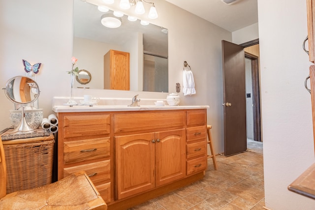 bathroom featuring a shower with door and vanity