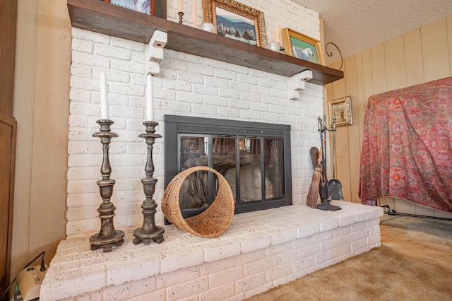 details featuring carpet floors, a brick fireplace, wooden walls, and a textured ceiling