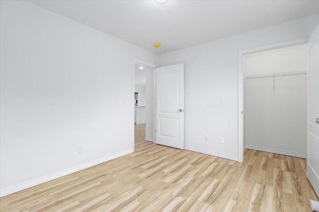 unfurnished bedroom featuring a closet and light hardwood / wood-style floors