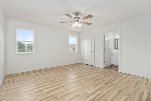 unfurnished bedroom with ensuite bath, light wood-type flooring, and ceiling fan