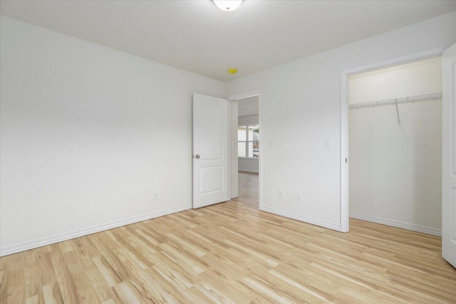 unfurnished bedroom with a closet and light wood-type flooring