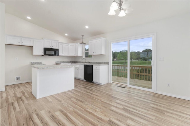 kitchen with white cabinets, hanging light fixtures, and black appliances