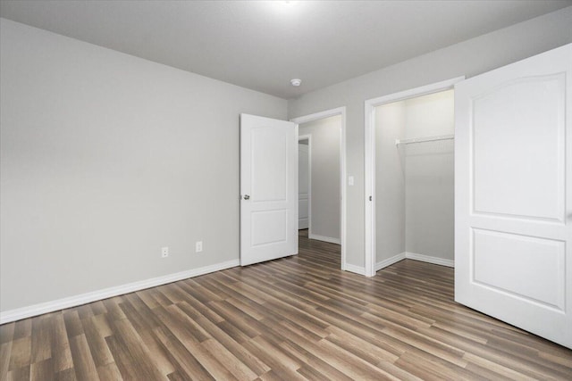 unfurnished bedroom featuring a closet and dark hardwood / wood-style floors