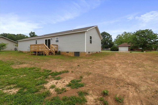 back of property featuring an outbuilding, a deck, and a garage