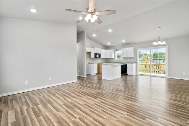 unfurnished living room featuring ceiling fan with notable chandelier, light wood-type flooring, sink, and high vaulted ceiling