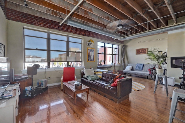 living room featuring hardwood / wood-style flooring and brick wall