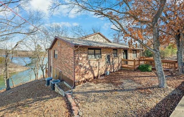 view of front of property with central AC and a deck with water view