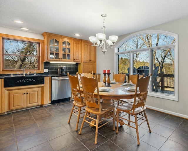 dining room featuring an inviting chandelier, sink, and dark tile patterned floors