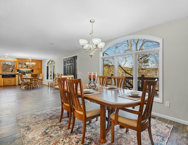 dining room featuring dark hardwood / wood-style floors, sink, and a chandelier