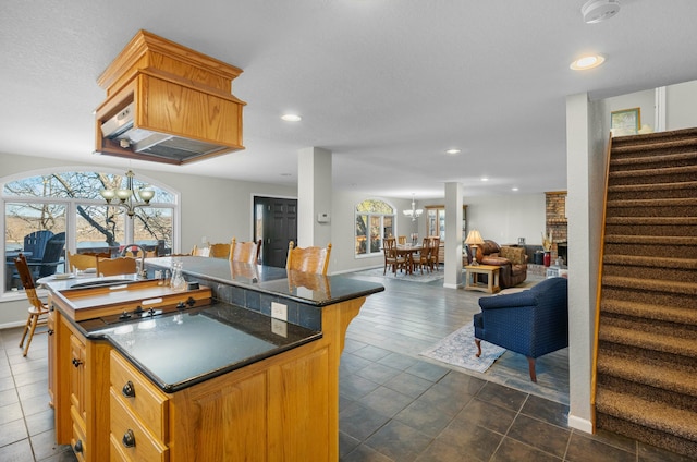 kitchen featuring dark tile patterned flooring, a kitchen island, and a notable chandelier