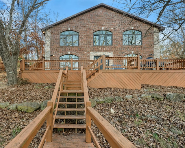 rear view of property featuring a wooden deck