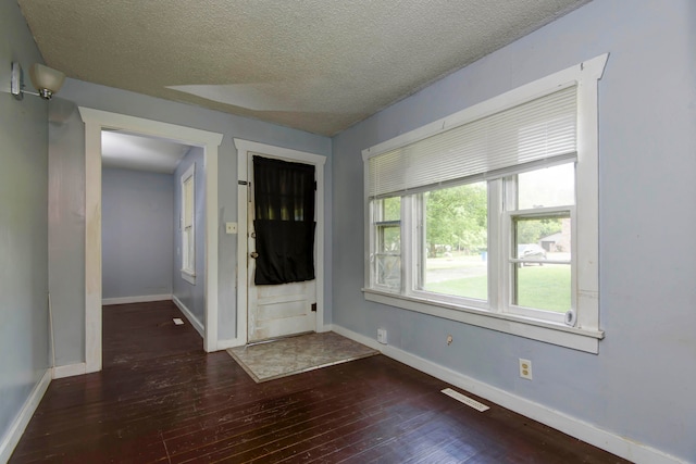 foyer featuring a textured ceiling and dark hardwood / wood-style flooring