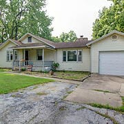 single story home featuring a garage and a porch