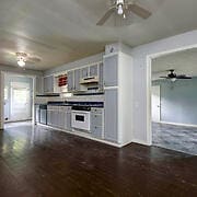 kitchen with ceiling fan, white oven, and wood-type flooring