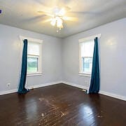 unfurnished room featuring dark hardwood / wood-style floors and ceiling fan