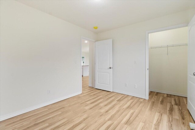 unfurnished bedroom featuring a closet and light wood-type flooring