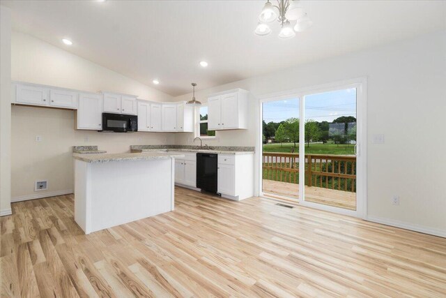 kitchen with lofted ceiling, decorative light fixtures, black appliances, and white cabinetry