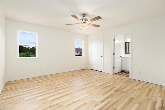 unfurnished bedroom featuring ceiling fan, connected bathroom, light hardwood / wood-style floors, and multiple windows