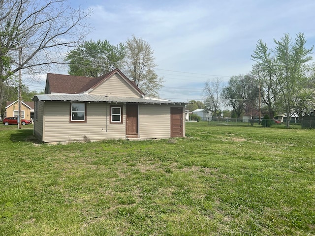 rear view of house featuring a lawn