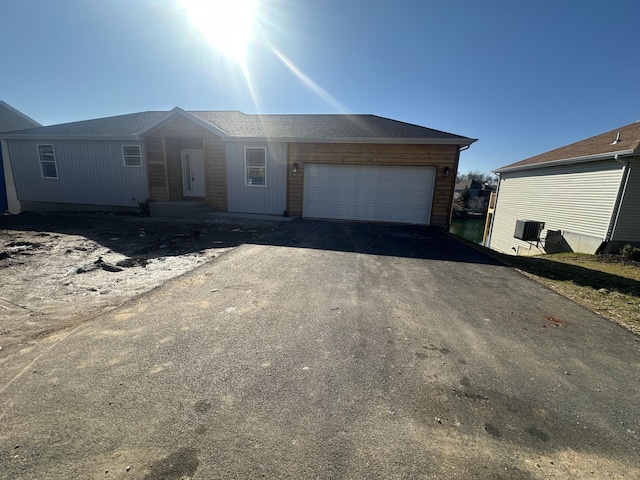 view of front of property featuring cooling unit and a garage