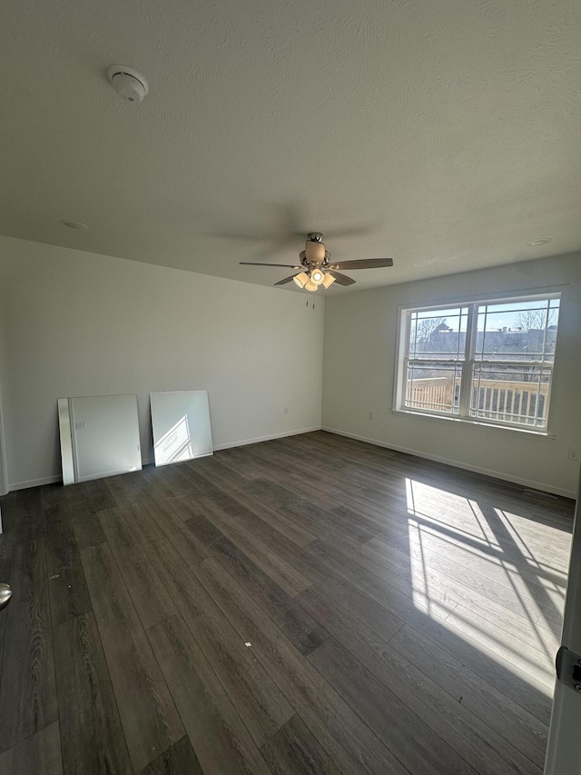 spare room featuring ceiling fan, dark hardwood / wood-style floors, and a textured ceiling