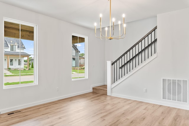 entryway featuring plenty of natural light, a chandelier, and light hardwood / wood-style flooring