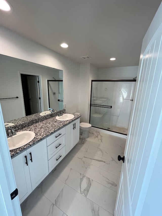 bathroom featuring vanity, walk in shower, and toilet