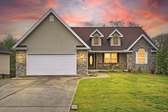 view of front of home featuring a garage, a lawn, and covered porch