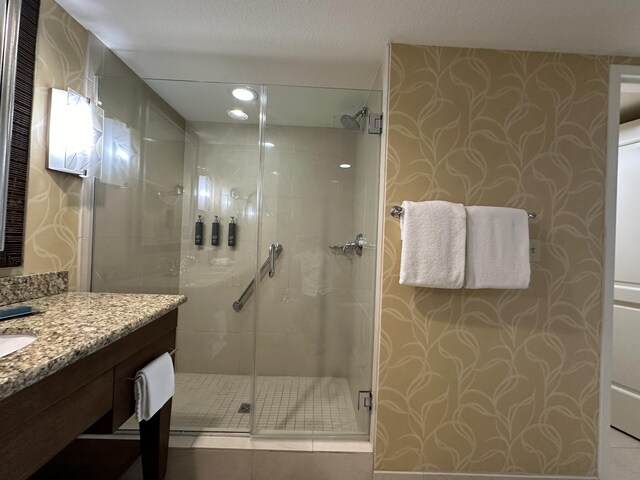 full bath featuring vanity, tile patterned flooring, and a stall shower