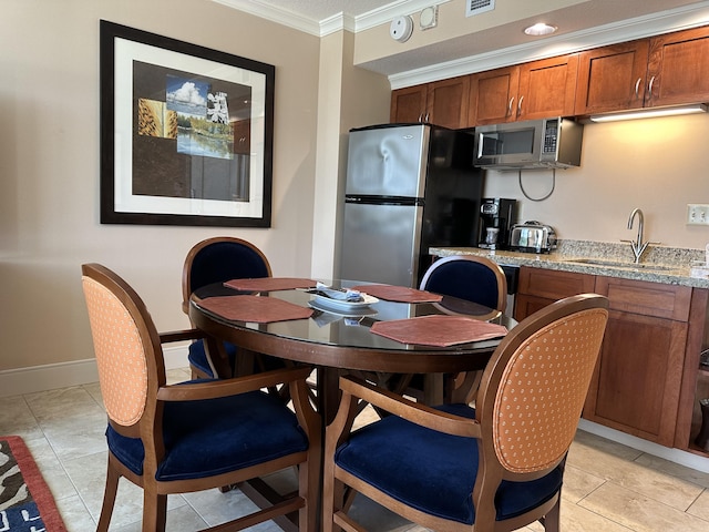 interior space featuring crown molding, a sink, brown cabinets, appliances with stainless steel finishes, and visible vents