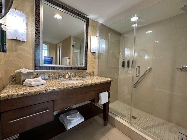 bathroom with tile patterned floors, walk in shower, and vanity