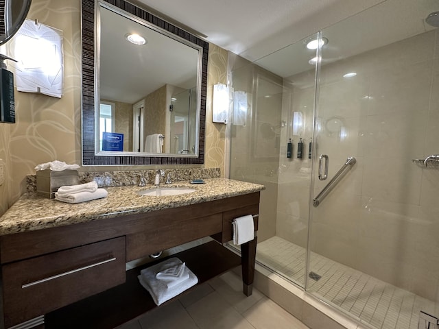 full bath featuring a shower stall, vanity, and tile patterned floors