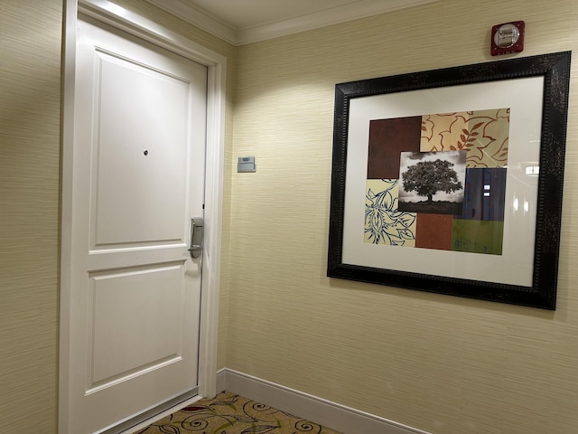 doorway with baseboards and crown molding