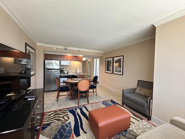 living area with visible vents, baseboards, a textured ceiling, and ornamental molding