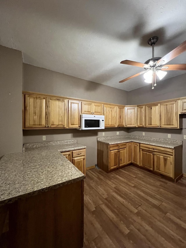 429 S Eagle Ave, Norwood, MO 65717 - kitchen featuring ceiling fan, white microwave, light countertops, dark wood finished floors, and a peninsula